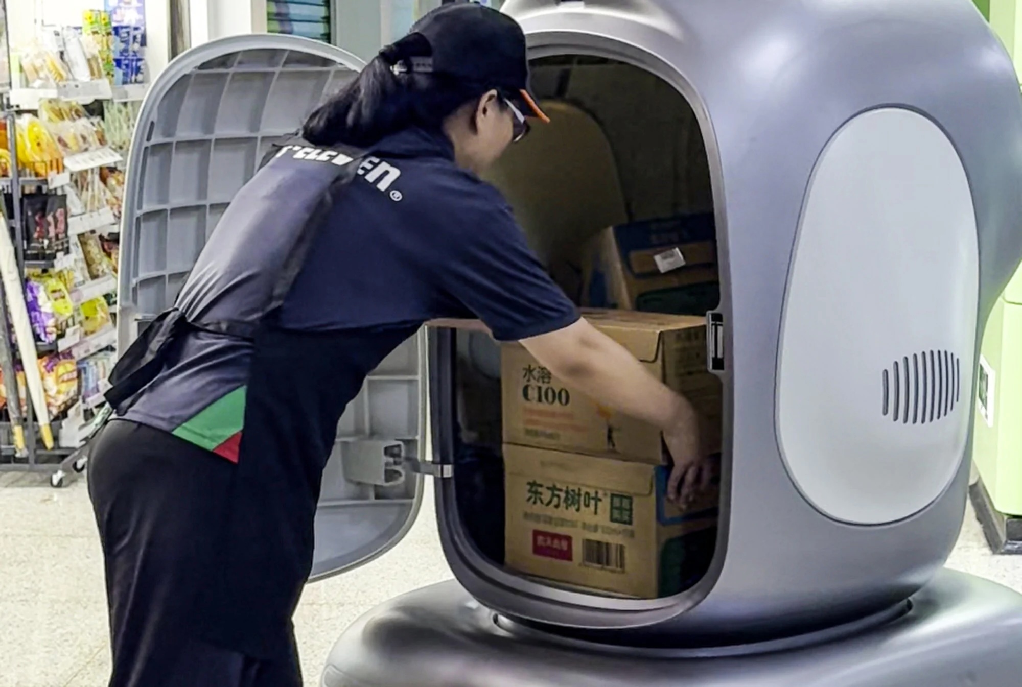 Сотрудница 7-Eleven разгружает робота-доставщика