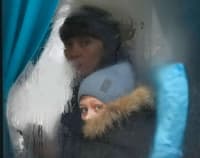 A woman and child peer out of the window of a bus as they leave Sievierodonetsk, Luhansk region, Ukraine, on Feb. 24.