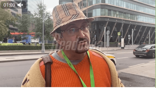 Readovka показала интервью с «простым москвичом, который хочет воевать». У него на шее — ленточка сотрудника RT