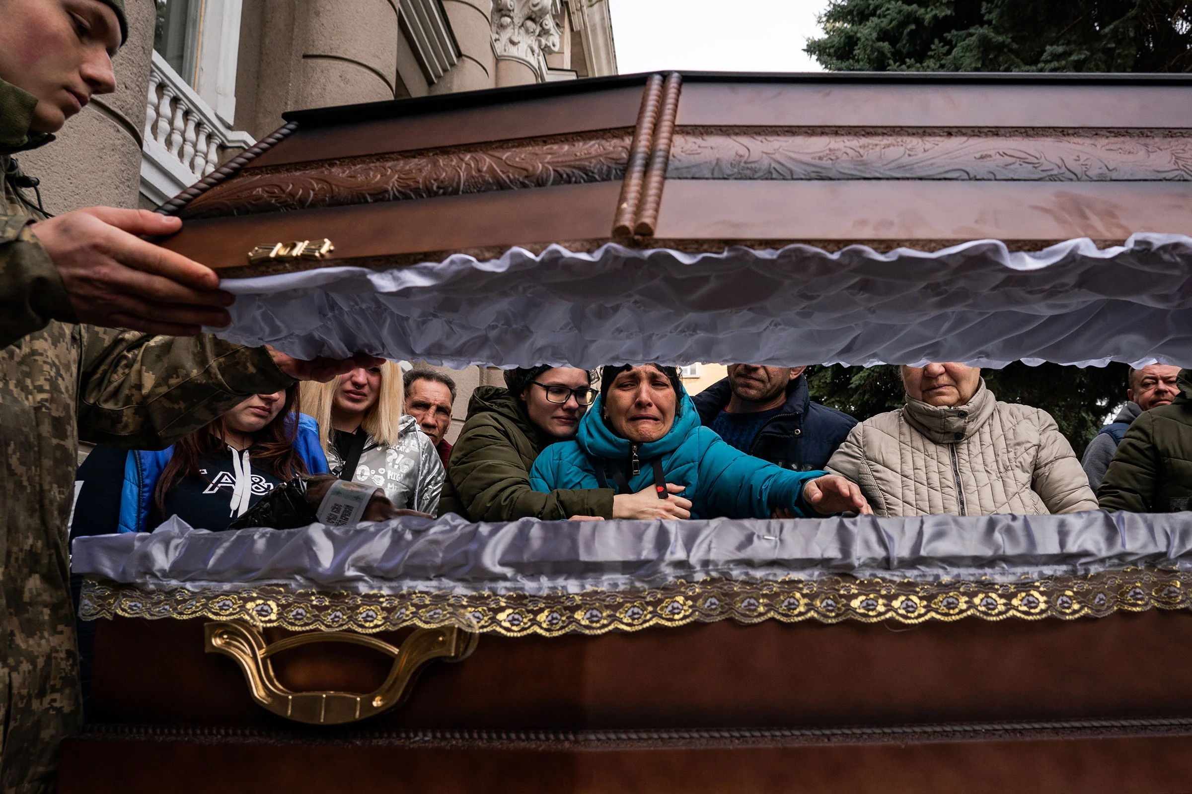 Семья украинского солдата Ивана Липского скорбит у его гроба в Одессе, Украина, 29 марта. Липский был убит в Николаеве 18 марта во время авиаудара российской авиации по 36-й бригаде морской пехоты Украины, погибло более 40 украинских солдат
