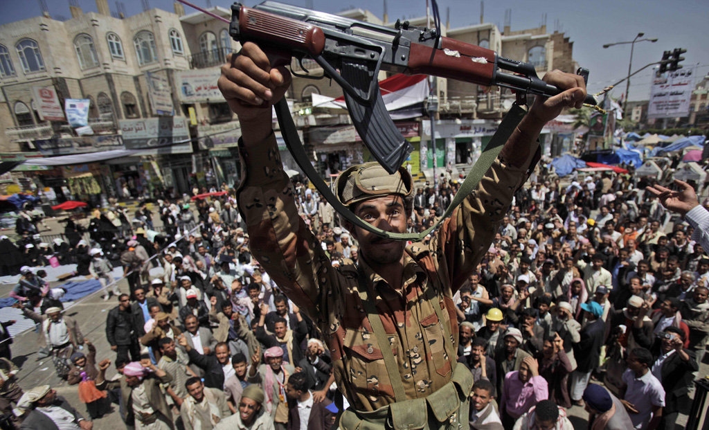 A Yemeni army officer holds up his AK-47 as he and other officers join anti-government protesters demanding the resignation of Yemeni President Ali Abdullah Saleh in Sanaa,Yemen, on Monday