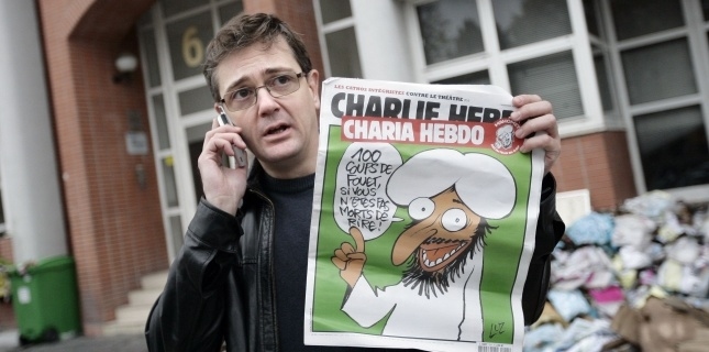 Charb-directeur-de-la-publication-de-Charlie-Hebdo-montre-lexemplaire-du-2-novembre-devant-les-locaux-frappés-par-un-attentat-à-Paris