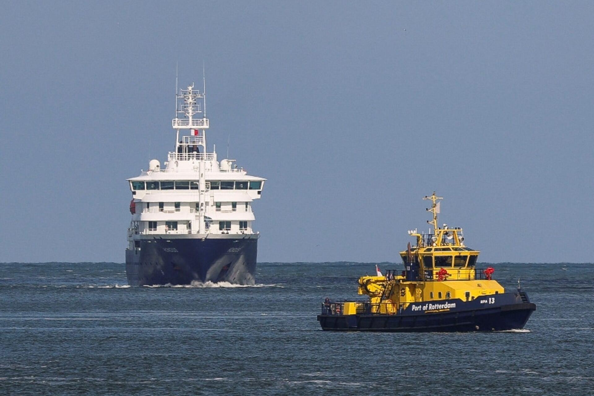 Патрульное судно сопровождает круизный лайнер MV Hondius, на борту которого произошла вспышка хантавируса, в порту Роттердама, 18 мая 2026 года. Фото: Yves Herman / Reuters