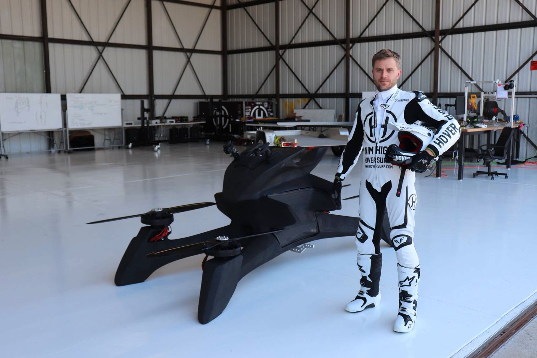 Alexander Atamanov poses next to a prototype hoverbike, 2018