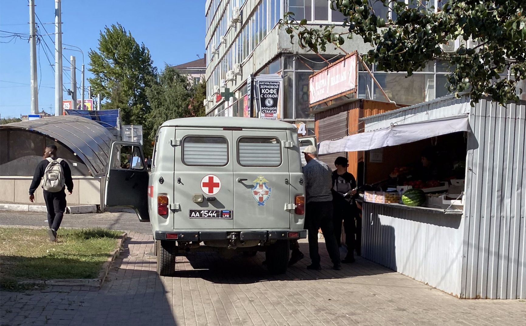 Soldiers in a car with “Luhansk People's Republic” license plates buy watermelons in Kursk