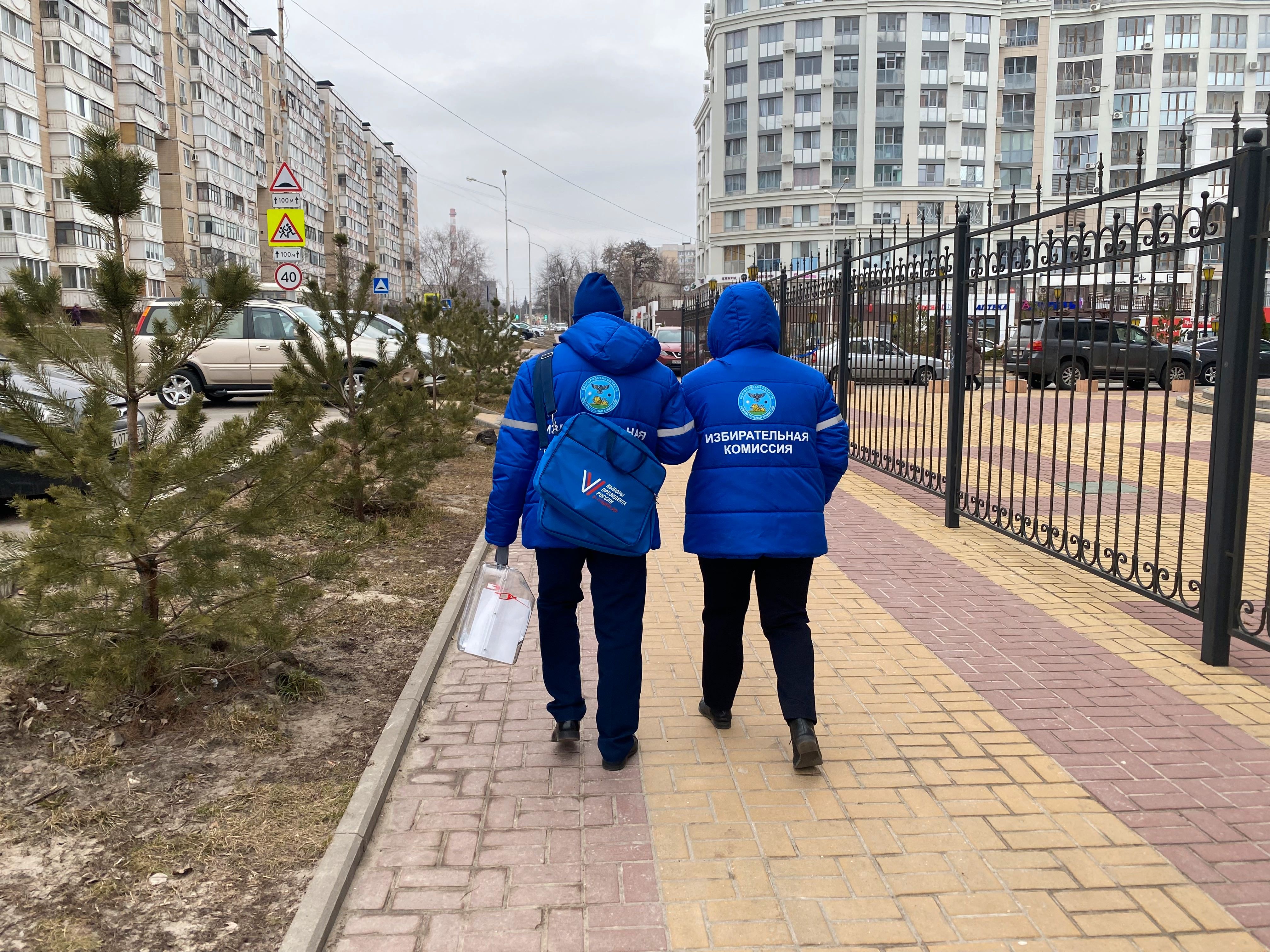 Members of the precinct election commission carry a ballot box