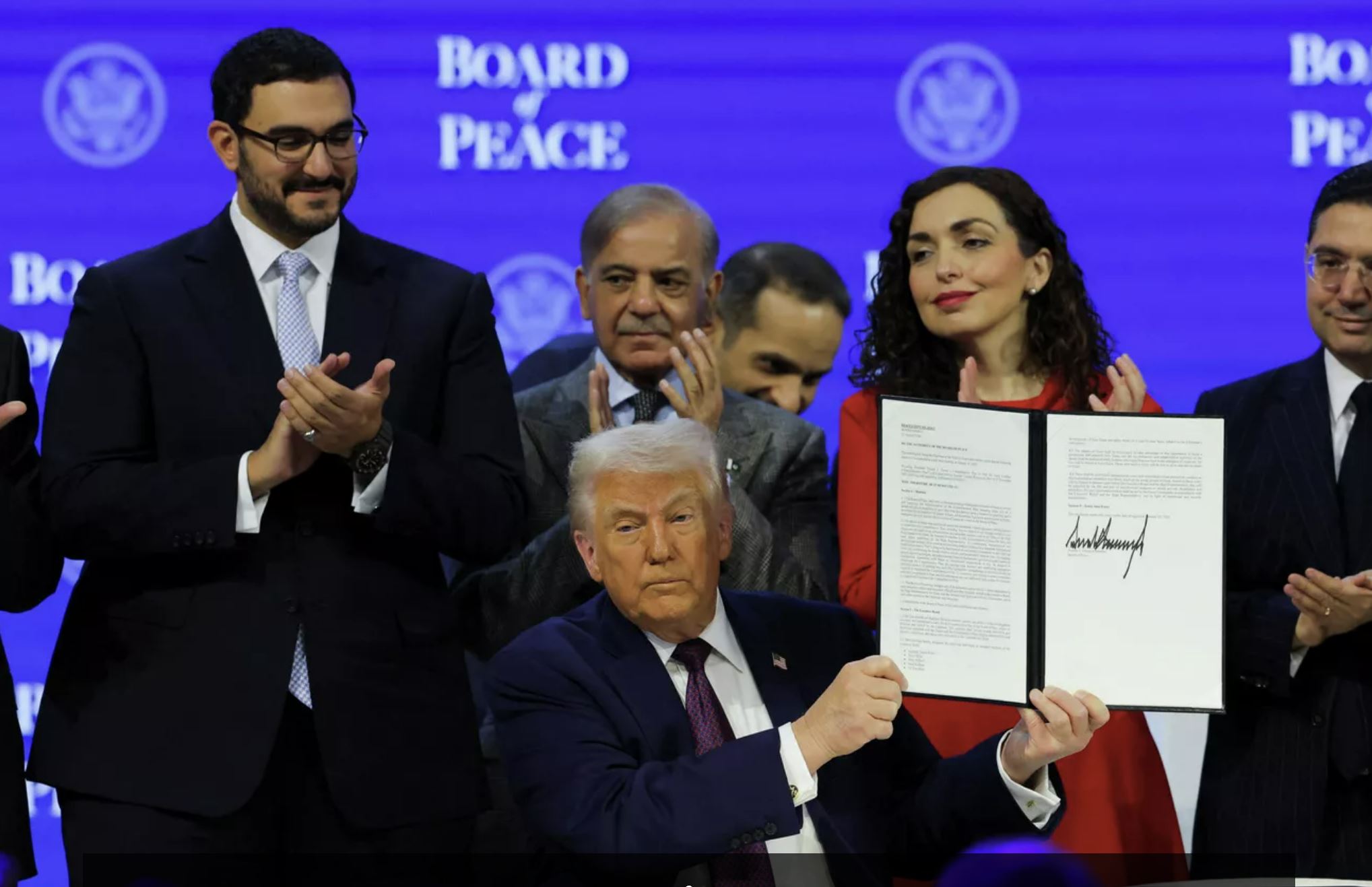 Дональд Трамп держит в руках подписанный устав Совета мира