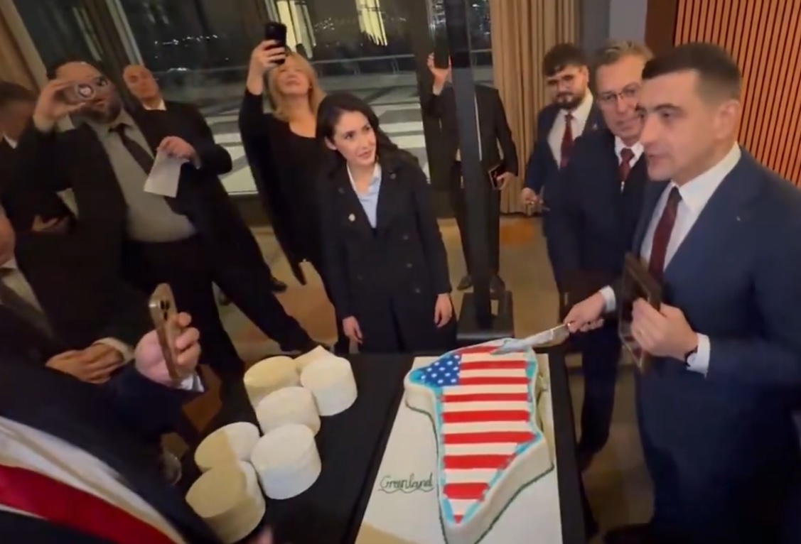 Джордже Симион (справа) и Анна Паулина Луна разрезают торт в форме Гренландии