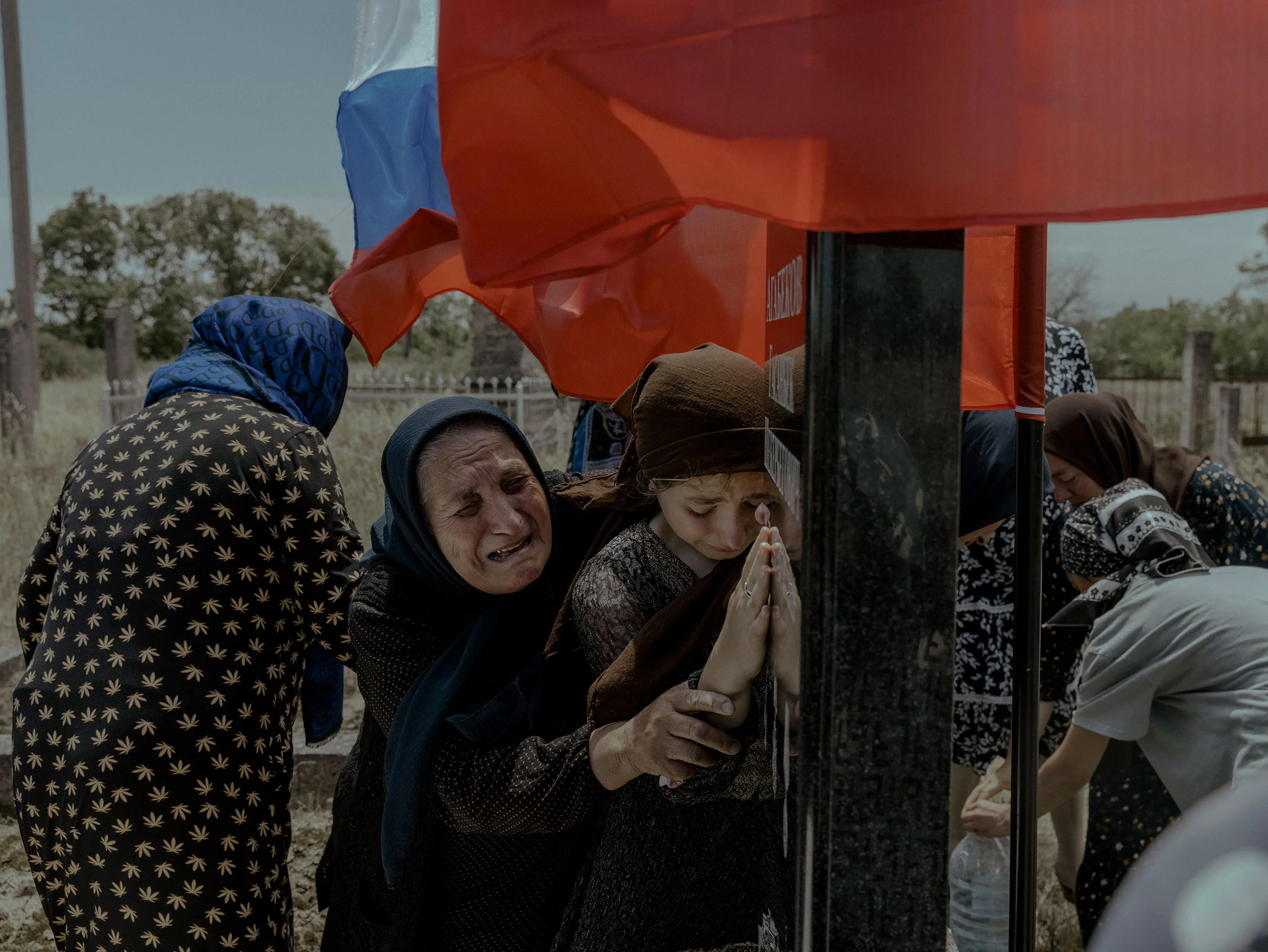 Женщины оплакивают смерть члена своей семьи, солдата-срочника Гасанбека Агабекова, убитого в Украине 27 мая. Фото сделано Аглоби, Дагестан, Россия, 16 июня. В Дагестане члены семей погибших регулярно встречаются, чтобы скорбеть. Имам сказал, что еще пятнадцать мужчин из района Гасанбека погибли на войне. Республика, понесшая наибольшие потери по количеству жертв на войне в Украине, также является одной из самых бедных в России