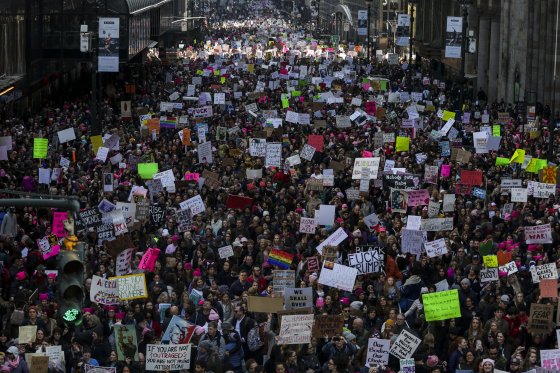 Demonstrators hold signs and march towards Trump Tower during the Women