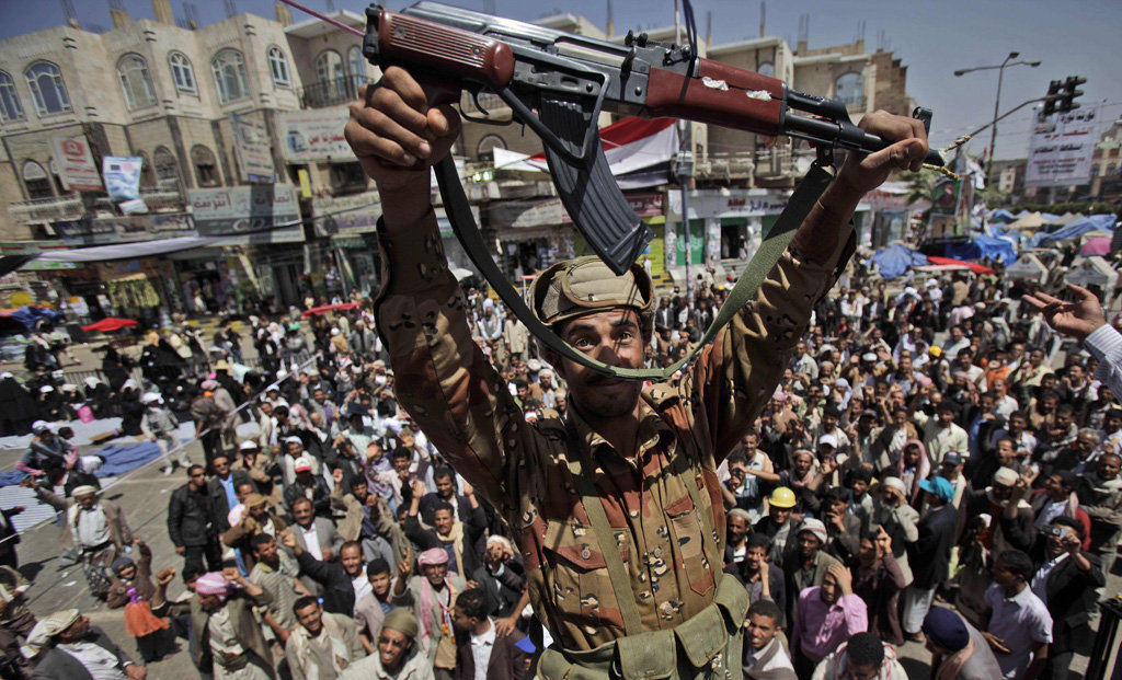 A Yemeni army officer holds up his AK-47 as he and other officers join anti-government protesters demanding the resignation of Yemeni President Ali Abdullah Saleh in Sanaa,Yemen, on Monday