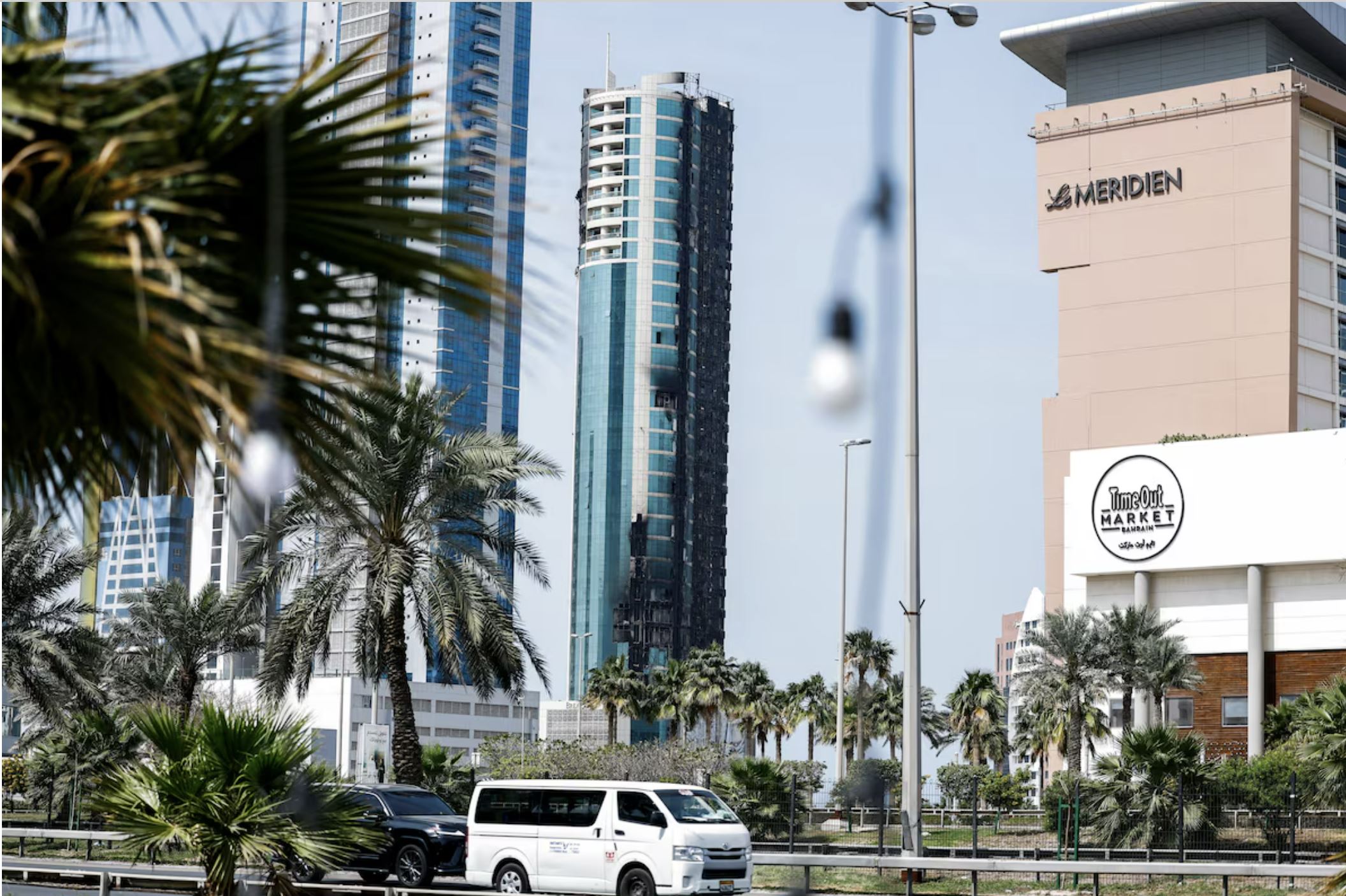 Автомобили проезжают мимо здания, поврежденного иранским беспилотником после ударов Израиля и США по Ирану, в городе Сиф, Манама, Бахрейн, 1 марта 2026 года. REUTERS/Hamad I Mohammed